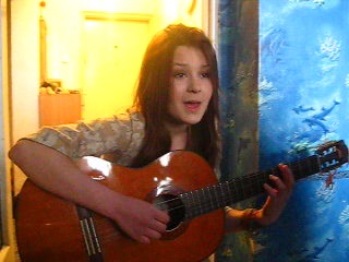 beautiful girl sings beautifully with a guitar